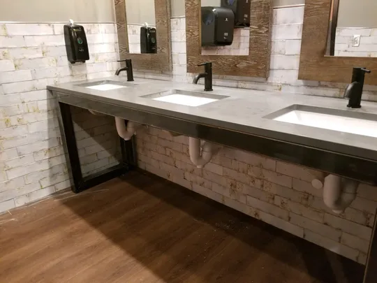 Steel-framed concrete restroom vanity